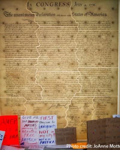 protest signs in front of large copy of the Declaration of Independence