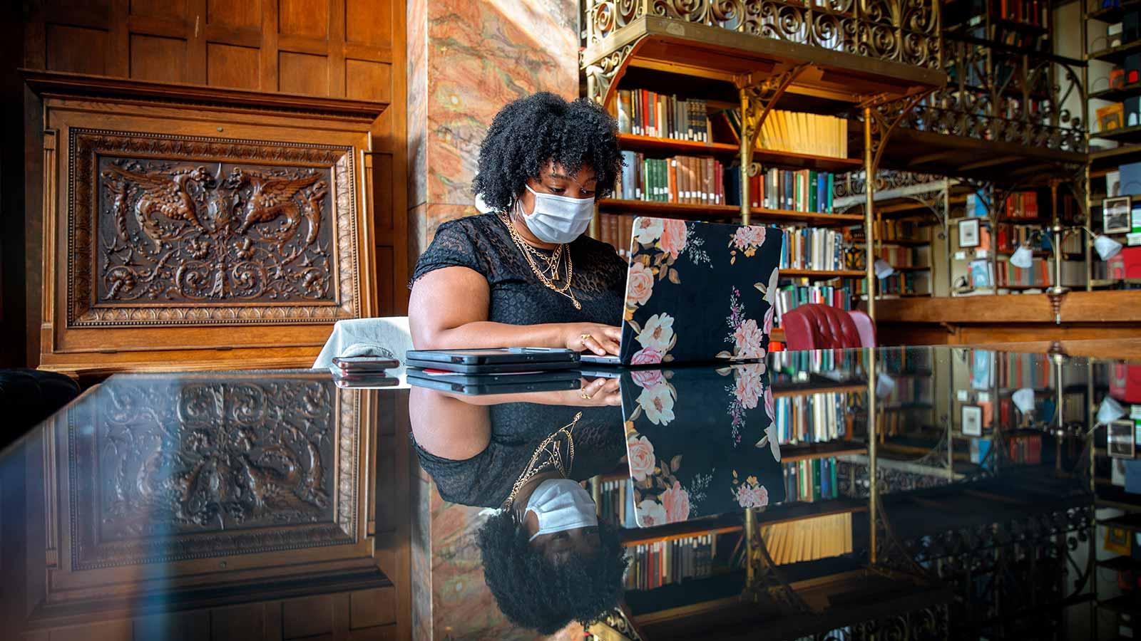Masked student studying in a library