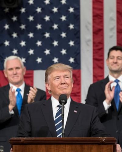 President Trump standing at a podium infront of American flag